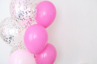 Bir demet pembe ve şeffaf hava balonu gümüş konfetili, metin için kopya alanı, kızlar için yumuşak pastel renkler