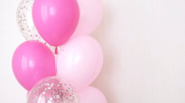 Bir demet pembe ve şeffaf hava balonu gümüş konfetili, metin için kopya alanı, kızlar için yumuşak pastel renkler