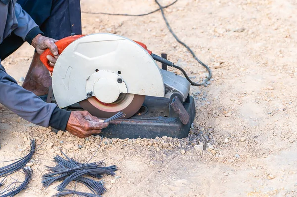 stock image Man's hand using iron cutter in the workplace, fastening iron canopy frame with spark. Worker cutting steel with electric iron cutter. Steel cutter grinder cutting iron pipe with bright sparks.