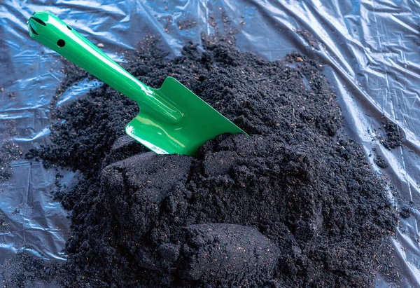 stock image Preparation of soil mixture from fertile compost, humus and vermiculite on  black garbage bag floor in garden. Mixing the soil components for the preparation of the substrate for transplanting plants.