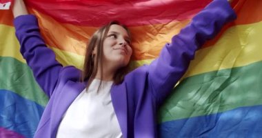 Lgbt kadınları evde gökkuşağı bayrağıyla dans ediyorlar. Sarıl ve tut. Mutlu bayan ve gülümse. cinsel çeşitlilik, LGBTQI, Gurur Etkinliği, LGBT Onur Ayı, lezbiyen mutlu bayan portresi.