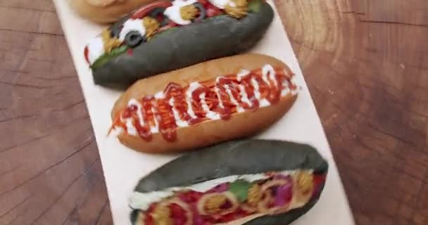 Perros Calientes Bollos Con Mostaza Ketchup Ensalada Zanahorias Tomates Aceitunas — Vídeos de Stock