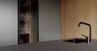 Açık Ahşap Duvar ve Zemin. Modern mutfak ve bar kahverengi sandalyeler minimalist dairede mutfak odasında. Minimalist yemek masası olan modern mutfak odası. Modern lavabolu Ev Mutfağı.