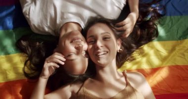 LGBT bayrağında kadın çift. Sarıl ve tut. Sevgiler ve öpücükler, LGBTQ, LGBT hakları, lezbiyen ailesi. Sevgi ve desteği paylaşan iki kadın el ele tutuşuyor. Yaşam tarzı ve ilişkiler.