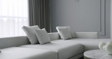 Modern Minimalist oturma odası. Köşedeki kanepe ve kitaplığı olan lüks modern ev iç mimarisi. Moda mobilyalar. Minimalist İç İşleri. Modern Mobilya Tasarımı. Lüks Zarif Oda