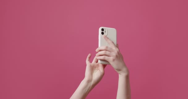 Młoda Kobieta Używa Smartfona Pokazuje Symbol Odosobnionym Różowym Tle Baner — Wideo stockowe