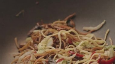 Profesyonel aşçı erişteli sebze kızartıyor. Asya tarzı yemek kompozisyonu. Yeni nesil mutfak deneyimleri. Lezzetli Asya eriştesi, lezzetli tavuklu erişte sebzeli karides..