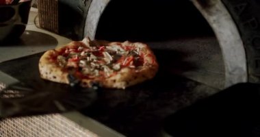 Şef restoran mutfağında pizza hazırlıyor. Büyük hamurlu İtalyan Napoli pizzası. Mutfakta çalış. Pizza ahşap fırına konur. Modern fırın. Pizza.. 