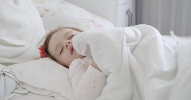 Yatak odasında huzur içinde uyuyan sevimli bir kızın yakın plan portresi.. 