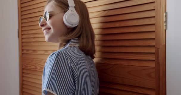 Ładna Dziewczyna Okrągłymi Okularami Przeciwsłonecznymi Bezprzewodowymi Słuchawkami Słuchającymi Muzyki Koncepcji — Wideo stockowe