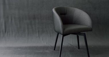 Modern izole gri arka planda gri minimalist sandalye. Rahat ve rahat bir sandalye. Evde, modern, rahatlatıcı koltukta oturuyor. Evdeki modern sandalyenin iç mimari tasarımı..