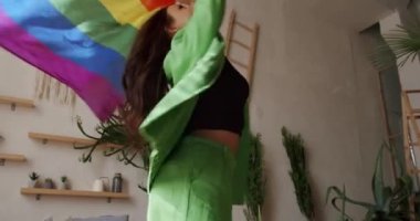 Mutlu lezbiyen kadınlar evde dinleniyor. İyi eğlenceler, LGBT bayrağıyla dans edin. Lezbiyen bayanın eğlendiği portre. LGBT hakları, lezbiyen ailesi. Yaşam tarzı LGBT konsepti