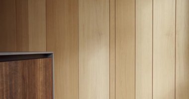 Evdeki ahşap mobilyalar ve duvar. Güneş ışığı odasındaki ahşap duvarın, mutfak odasındaki ahşap panellerin solundaki kereste dolabının görüntüsü..