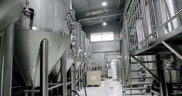 近代的な設備を備えたビール醸造所のインテリア 現代の醸造所でステンレス製円筒形タンクやビール製造装置の行の低角度 — ストック動画