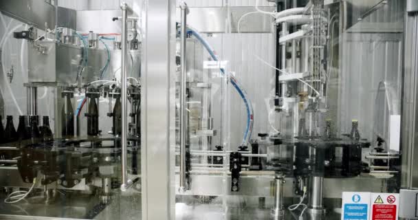 在啤酒厂工作的现代封顶机 啤酒生产过程中带有钢制瓶盖的现代工厂内部 — 图库视频影像