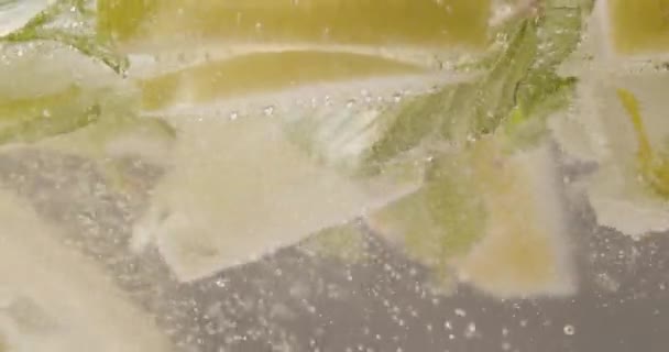 Căzând Lămâie Mentă Apă Spumantă Closeup Care Încadrează Lămâi Tăiate — Videoclip de stoc