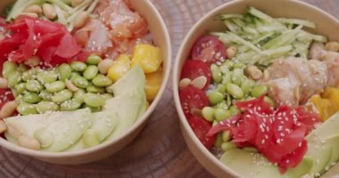 Japon yemeği, somon, karides, pirinç, avokado, edamame fasulyesi, ahşap zemin üzerinde salatalık. Sağlıklı yemek, keto diyeti konsepti. Asya çiğ yemeği.