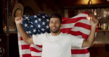 Barda futbol seyreden bir hayran. Dünya Kupası, Happy karışık yarış taraftarı kazandıktan sonra seviniyor ve tezahürat yapıyor. ABD bayrağı taşıyan bir adam bira içiyor ve maç seyrediyor..