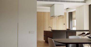 Güzel bir mutfak, yeni moda mobilyalar. Bir adası olan lüks bir mutfak. Minimalist bir mutfağın içinde. Açık Ahşap Duvar ve Zemin. Minimalist yemek masası olan modern mutfak odası.