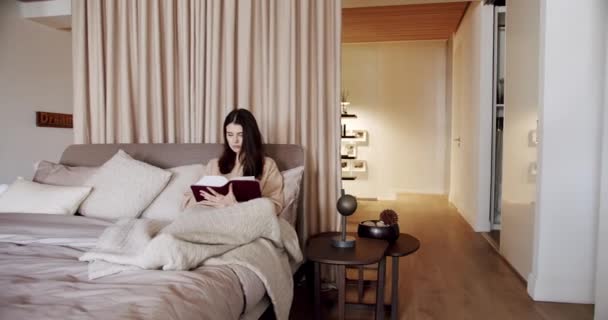 Mujer Relajándose Cama Leyendo Libro Dormitorio Casa Moderna Una Hermosa — Vídeos de Stock
