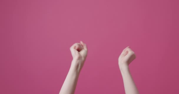 难以辨认的女性模特儿在庆祝胜利在粉红背景下庆祝成功的同时 收获妇女举起紧握拳头和拍手的静态镜头 — 图库视频影像