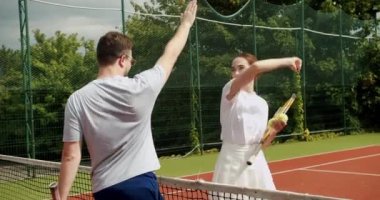 Bir kadın ve bir erkek birbirlerini selamlar ve maçın başında eğlenirler. Profesyonel tenis oynuyor. Hafta sonları ve pazarları eğlence amaçlı etkinlikler. Tenis oyuncuları iş başında. Tenis maçı.