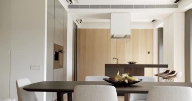 Yeni moda mobilyalarla dolu güzel bir mutfak. Bir adası olan lüks bir mutfak. Minimalist yemek masası olan modern mutfak odası. Modern lavabosu olan yerli mutfak. Şık minimalist iç mimari