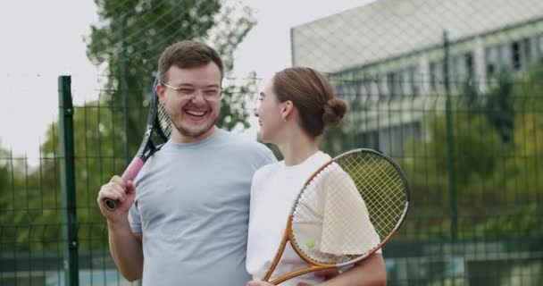 比赛成功后 夫妻二人在网球场上散步 周末和周日的娱乐活动 和朋友一起积极参加体育活动 朋友们在笑 玩得开心 赛后网球选手 — 图库视频影像