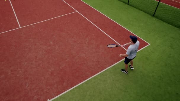 朋友们在室外的地毯球场上打网球 上下颠倒 无人驾驶飞机射击 一个人打网球 周末和周日的娱乐活动 网球选手在行动 网球比赛 积极休闲游戏 — 图库视频影像