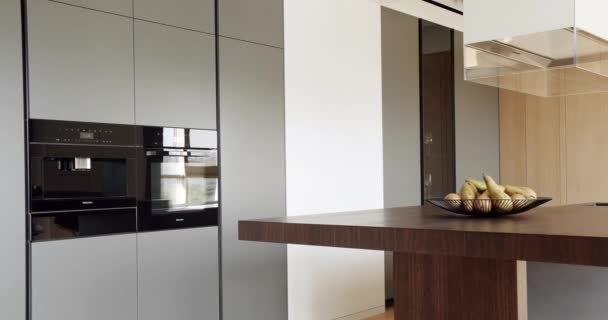 豪华住宅的现代室内装饰 最简约的厨房的内部轻木墙和地板 简约公寓厨房房间里的现代厨房和酒吧褐色椅子 现代家庭内部概念 — 图库视频影像