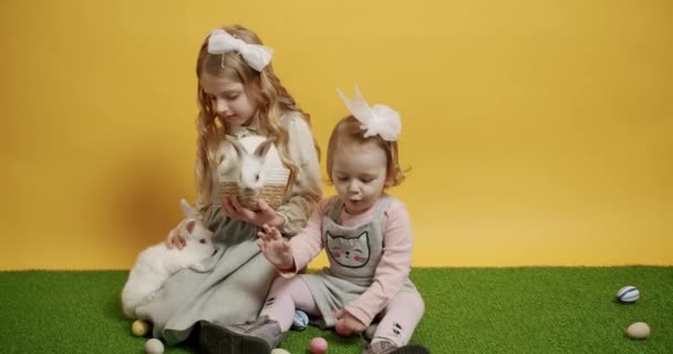 Barn Leker Med Kaniner Och Hålla Korg Med Färgade Ägg — Stockvideo