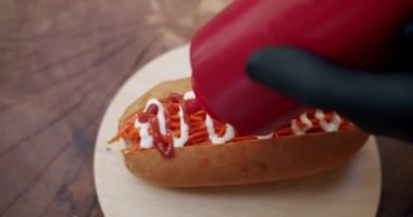 İştah açıcı sosisli sandviç. Ev yapımı sosisli sandviç, hardal, ketçap, salata, havuç ve bir sürü malzeme. Büyük şehirde sokak yemekleri.