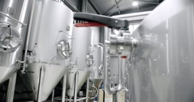 Bira fabrikasında büyük paslanmaz fıçılar. Bira fermantasyonu için ekipman. Bira ekipmanları. Fabrika, bira fabrikası kavramı. Özel mikro bira fabrikasındaki büyük rezervler, tanklar ve borular..