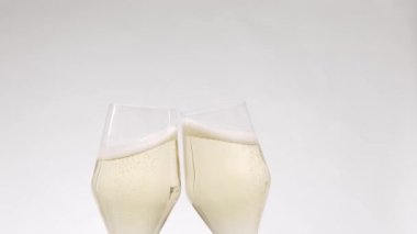 Two glasses of champagne on white isolated background, Cheers. Hands of happy friends cheering celebrating holidays with wine. say a toast.