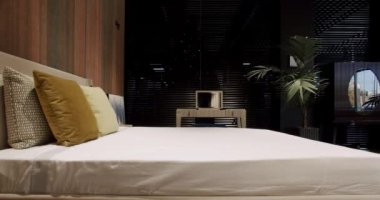 Modern Hotel Bedroom Interior and bed with many pillows. minimalistic scandinavian style of interior. Real Estate. Interior of modern luxury bedroom with furniture.