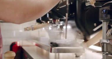 Pouring coffee stream from machine in cup. Espresso in a white cup. Espresso machine making fresh coffee. Flowing fresh ground coffee. Drinking roasted black coffee.