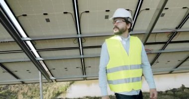 Checking the panels at solar energy installation. Solar cells will be an important renewable energy of the future. The technician in uniform makes notes in the notebook.