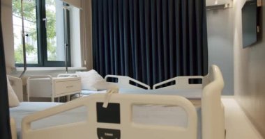 Two empty bed in a hospital room with medical equipment. Cozy room in medical clinic indoors with no people. Concept of medicine and service. Emergency Services. Empty Patient Room In Modern Hospital.