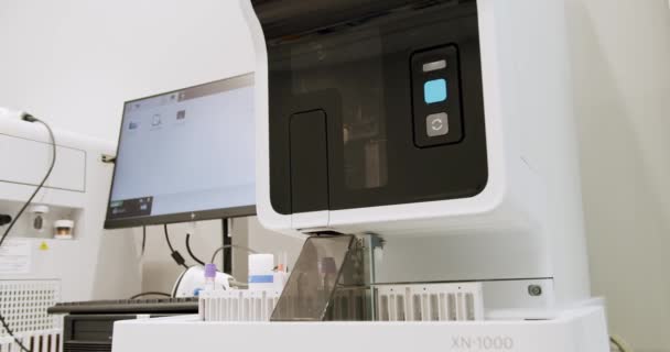チューブ付き血液検査機 コンピューター機器を使った血液検査 血液検査機は実験室でサンプルをチェックします 作業プロセス中の自動化されたマシン 血液や尿のサンプル分析 — ストック動画