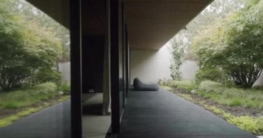 Terrace outside modern house in summer. Terrace with soft bean bag located near lush bush outside contemporary house on summer day