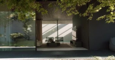 Living room behind glass door. Static shot of interior of stylish living room located behind opened door and glass door of modern house on summer windy day