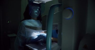 In the Hospital, Mammography Technologist. Doctor Pushes Button on Mammogram Machine Activating Female Patient Scan. Woman Does Cancer Preventive Mammogram Scan in Radiology Room.