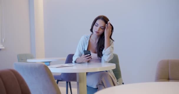 Woman Using Smartphone Waiting Room Pan Right View Young Brunette — Vídeo de stock