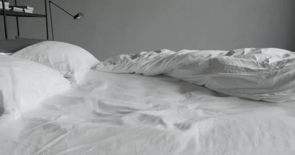 寝室のベッドのための白いDuvetとミニマリストのベッドルーム モダンなベッドルーム多くの枕とインテリアとベッド ミニマルなスカンディナヴィア風のインテリア キングサイズベッド付きのエレガントでシンプルなベッドルーム — ストック動画