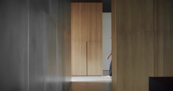 男人走进了房子 现代简约主义客厅 有木墙 奢华的现代住宅内部 简约家庭内部 舒适的现代家具设计 奢华雅致的房间 — 图库视频影像