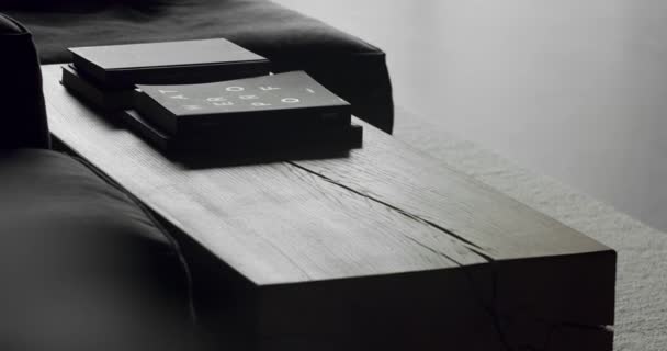 在一个现代简约主义客厅里 用黑色家具 木制桌子和书籍关上熟食店 奢华的现代住宅与角落索法和书架 时尚家具 — 图库视频影像