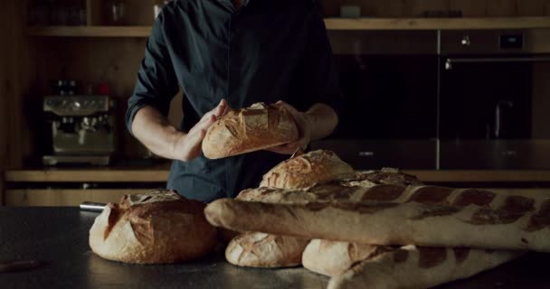 Мужчина Черной Рубашке Современной Просторной Деревянной Кухне Разрезал Круглый Хлеб — стоковое видео