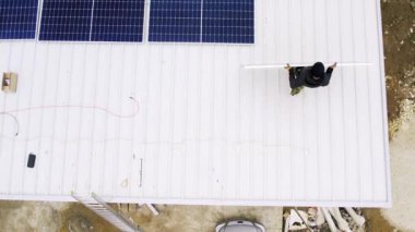  Solar technician installing solar panels on house roof. Concept.renewable energy, technology, electricity, service, green, future. power plant. Modern solar panels produce clean electricity.