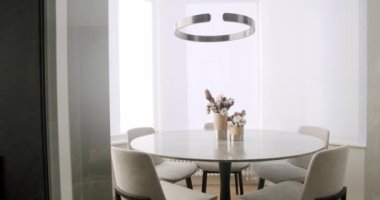  Minimalist Modern White Dining Room with white chairs and minimalist lamp. Minimalist Dining Table. luxury kitchen in modern style, Elegant table and chairs. Dinner. White Simple Modern Interior.