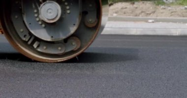 Road Paving on Residential Street. Asphalt laying. Road building asphalt paver is laying a new layer of asphalt, Road rollers drive on a new road. Roadway repair. Heavy machinery.